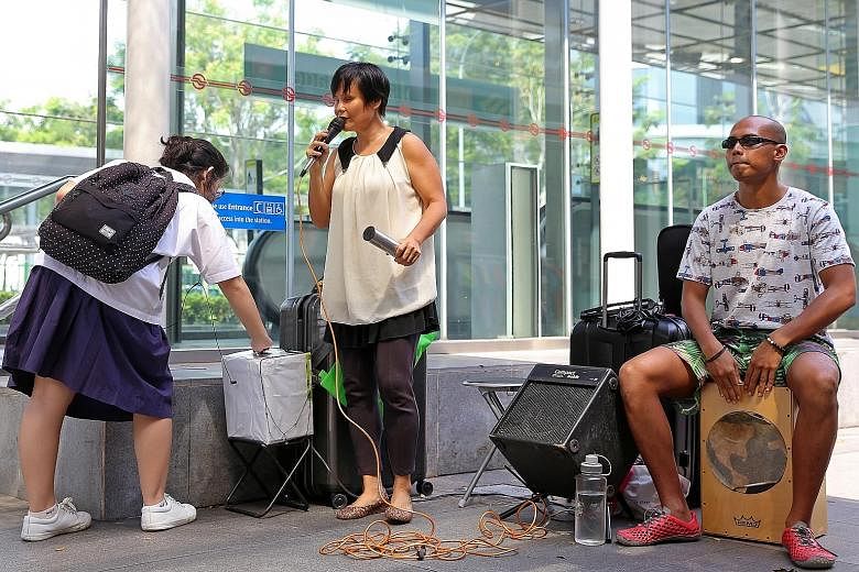 One of the grant recipients, Ms Wan, with her busking partner, Mr Ivni, outside Holland Village MRT. The award programme will provide weekly music lessons for Purple Symphony members.