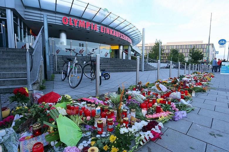 A memorial of candles and flowers laid outside the Munich shopping mall.