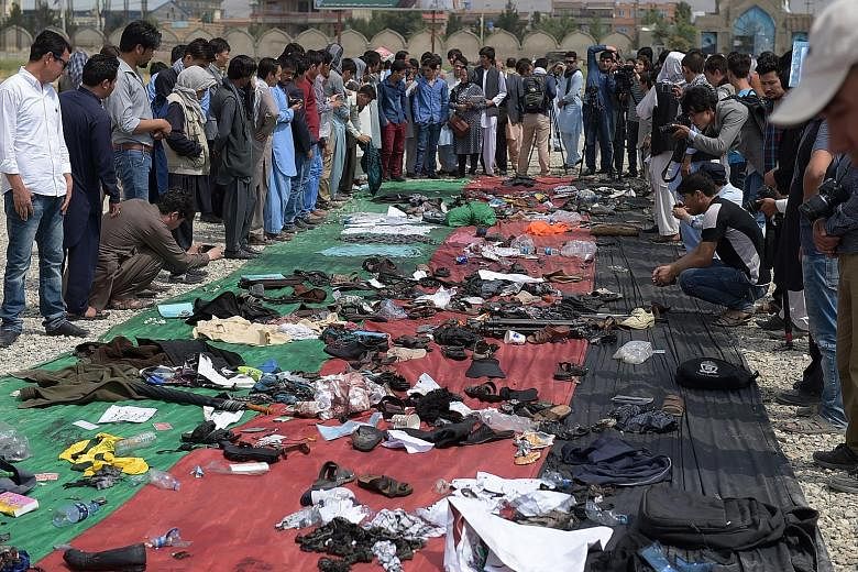 Afghans sorting through the belongings of their relatives and friends killed in the suicide bombing claimed by ISIS.
