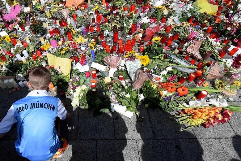 The assault by Ali Sonboly, 18, appeared to be less ideological and more personal. A boy at a memorial in front of the Olympia Einkaufszentrum shopping centre in Munich, where a lone gunman shot and killed nine people on Friday.