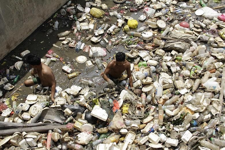 Workers clearing the trash trapped in a part of Batu River in Selangor.