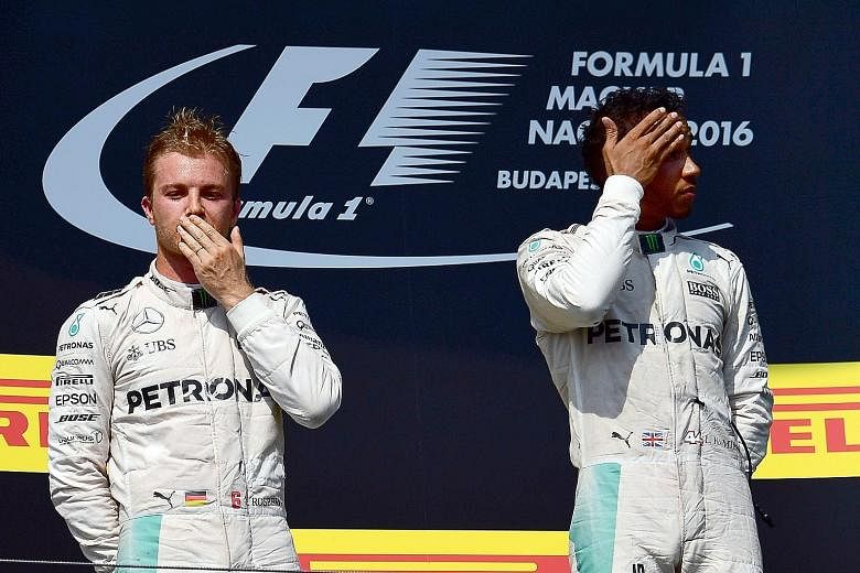 Nico Rosberg (left) and Lewis Hamilton await the anthems on the podium after the Hungarian Grand Prix on Sunday.