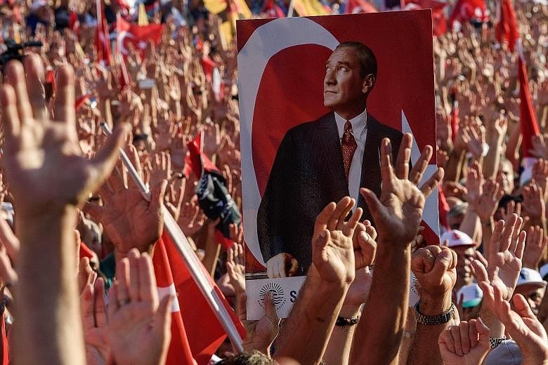 Demonstrators gathering around a picture of Mustafa Kemal Ataturk, founder of modern Turkey, during an anti-coup rally on Sunday organised by Turkey's largest opposition group, the Republican People's Party.