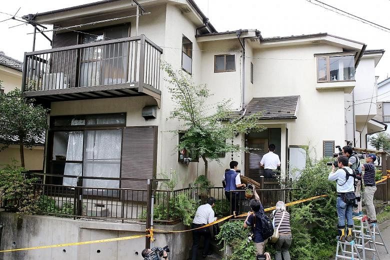 Police entering the house of Satoshi Uematsu yesterday while reporters and television crews stood outside. Uematsu had turned himself in at a police station after going on a killing spree on Tuesday.
