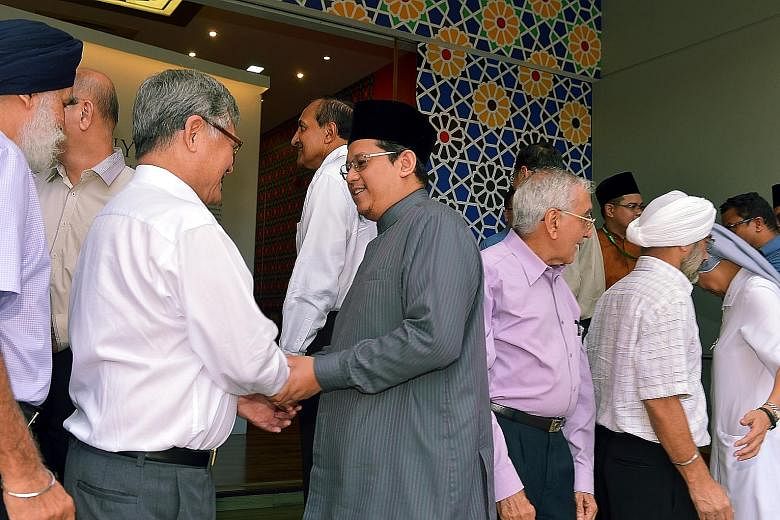 The Mufti of Singapore, Dr Fatris Bakaram (in grey), greeting leaders of Singapore's major faiths at a tea reception, in celebration of Hari Raya Puasa, at the Harmony Centre in Bishan yesterday.