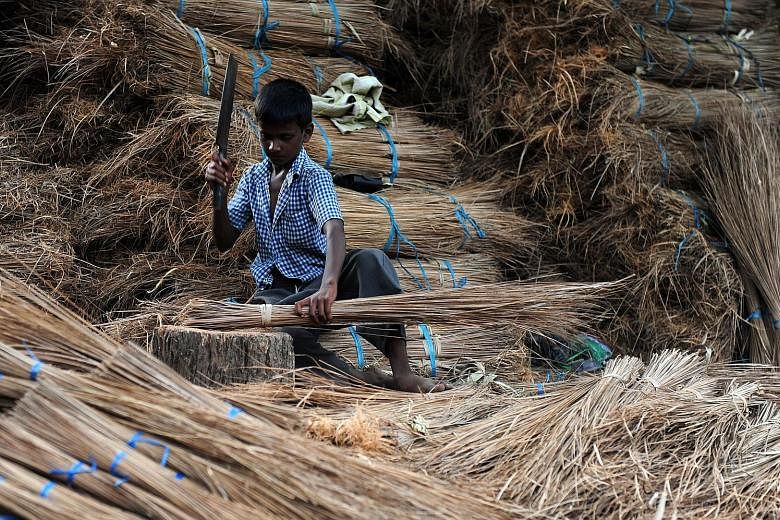 A young labourer chopping coconut leaves and sticks at a broomstick production facility in Chennai. A 2015 report by the International Labour Organisation put the number of child workers in India aged five to 17 at 5.7 million.