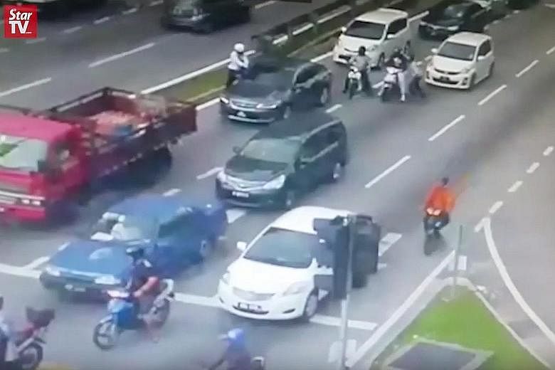 Video screenshots show four men on two motorcycles approaching the victim's car, which had stopped at a traffic light near Setapak Central mall in KL. Two of them fired the shots and they fled shortly after.