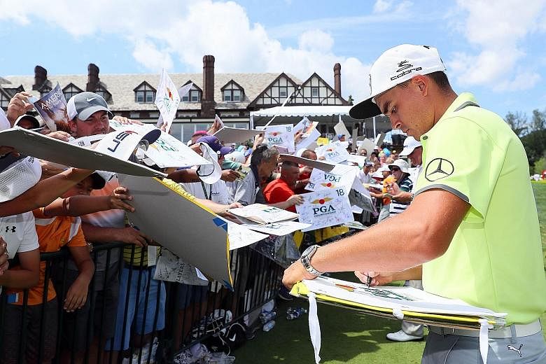 American Rickie Fowler signing autographs for fans during a practice round ahead of this week's PGA Championship.