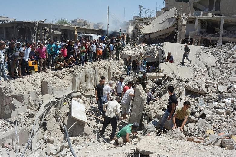 People looking for survivors amid the ruins of a building destroyed by the blast in the Syrian city of Qamishli yesterday. ISIS said the bombing was revenge for "crimes committed by crusader coalition aircraft".