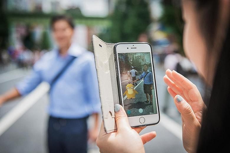 A woman plays the augmented- reality game Pokemon Go in Tokyo, Japan.
