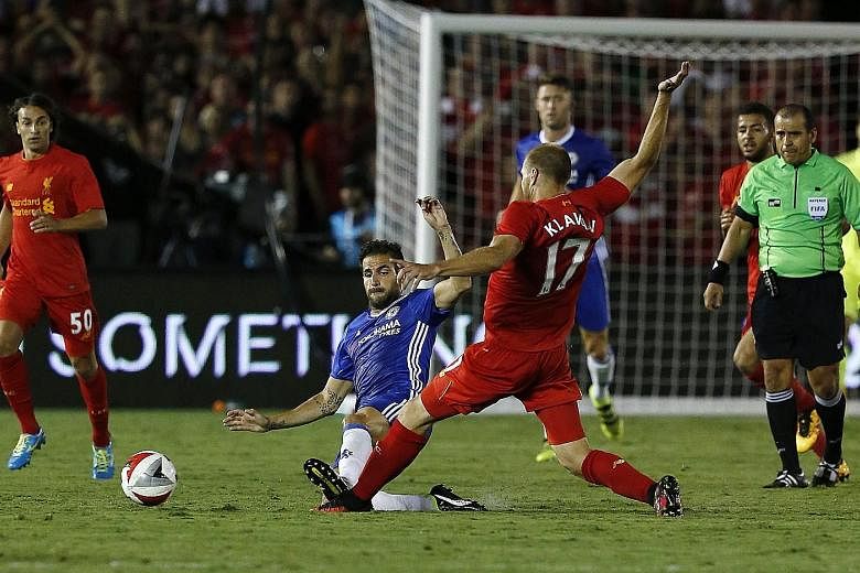 Chelsea midfielder Cesc Fabregas (left) slides into a challenge on Liverpool defender Ragnar Klavan in the 70th minute of a friendly. The Spain international was sent off.
