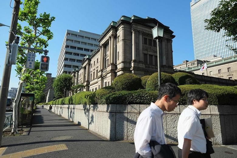 The BOJ's headquarters (above) in Tokyo. Mr Kuroda (left) and his team enlarged a programme of buying exchange- traded funds and expanded a US dollar-lending facility, but did not raise the target for the monetary base.