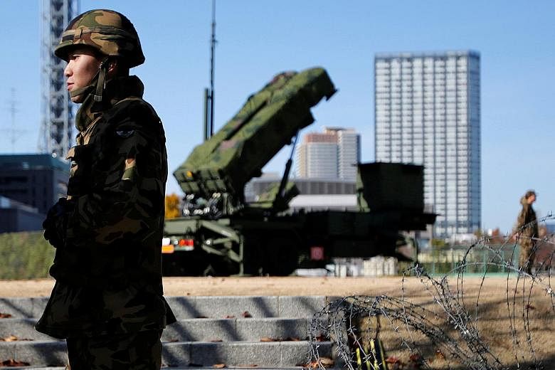 Members of the Japan Self-Defence Forces standing guard near PAC-3 land-to-air missiles, deployed at the Defence Ministry in Tokyo. The new upgrade could enhance the range and accuracy of the missiles needed to intercept North Korean ballistic missil