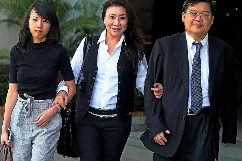 Shi (centre) leaving the State Courts with lawyers Melissa Kor and lrving Choh. She has been embroiled in a dispute with her neighbour over her raintree in Astrid Hill, and was ordered last week to pay $9,800 in damages to the neighbour and to trim t