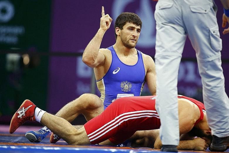 Russia's Aniuar Geduev (in blue Asics kit) will be part of his country's 16-man wrestling team to compete in Rio de Janeiro next week, after they were cleared by United World Wrestling.