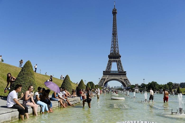 The hot weather drove many to take a break in front of the Eiffel Tower earlier this month. Elsewhere in Paris, rental apartments are staying empty after people cancelled plans to visit France in the wake of recent terror attacks.