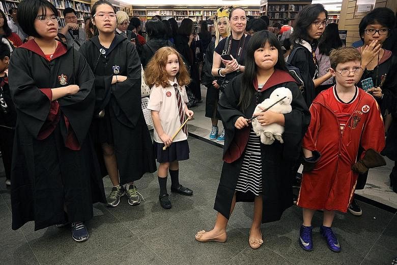 Fans of the Harry Potter series waiting to take part in a cosplay event at Books Kinokuniya yesterday. Major bookstores here opened at 7.01am to coincide with the international release of Harry Potter And The Cursed Child Parts I and II, the script f