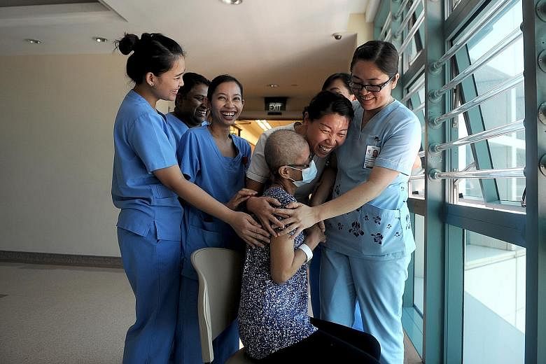 Cancer patient Madam Chai surrounded by the nurses who are taking care of her at Tan Tock Seng Hospital. From left: Ms Maria Santuyo, Ms Jeyanthi Raju, Ms Hanisah Noordin, Ms Lin Yunxia, Ms Jennifer Ortencio (partially hidden) and Ms Pwint Phyu Phyu 