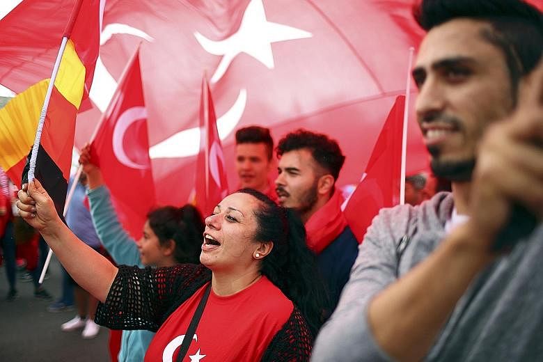 Supporters of Turkey's President Erdogan waving Turkish flags during a pro- government protest in the Germany city of Cologne yesterday.