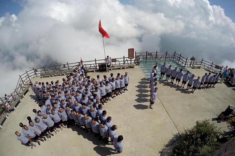 PLA navy veterans standing in formation on Sunday on top of a mountain ahead of China's Army Day in Luoyang, Henan province. President Xi plans to shed 300,000 troops from the 2.3 million-strong military, the centrepiece of China's biggest shake-up o