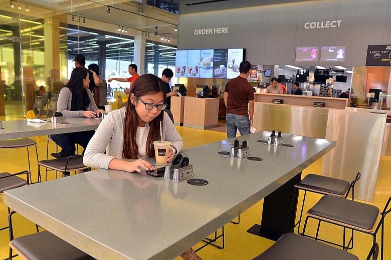 Communications executive Jale Ng (above) charging her mobile device at McDonald's Marine Cove outlet, one of the few places to have stations for wireless charging.