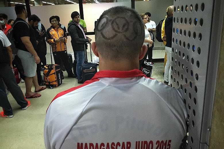 A Rio-bound Madagascar judo coach sports a haircut showing the Olympic logo as he waits in the boarding lounge at the Sao Paulo-Guarulhos International Airport.