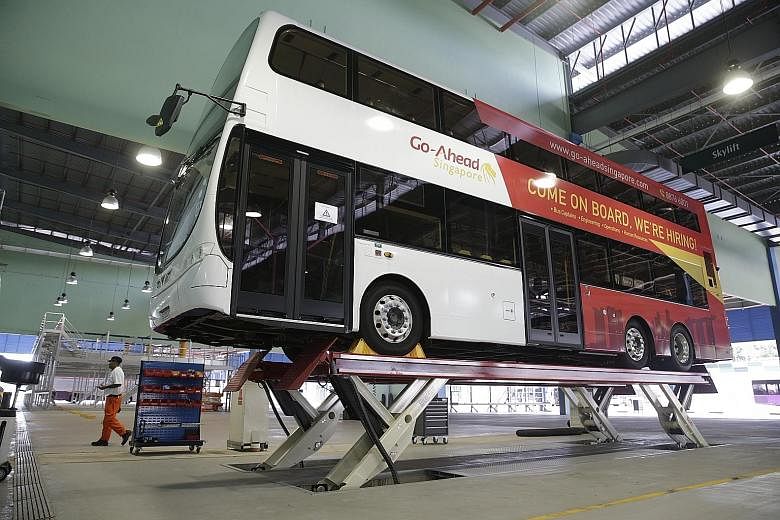 A Go-Ahead Singapore bus being hoisted in preparation for maintenance at the company's bus depot in Loyang. The operator is the second foreign bus company to join the industry under the bus contracting model, which aims to boost service standards.