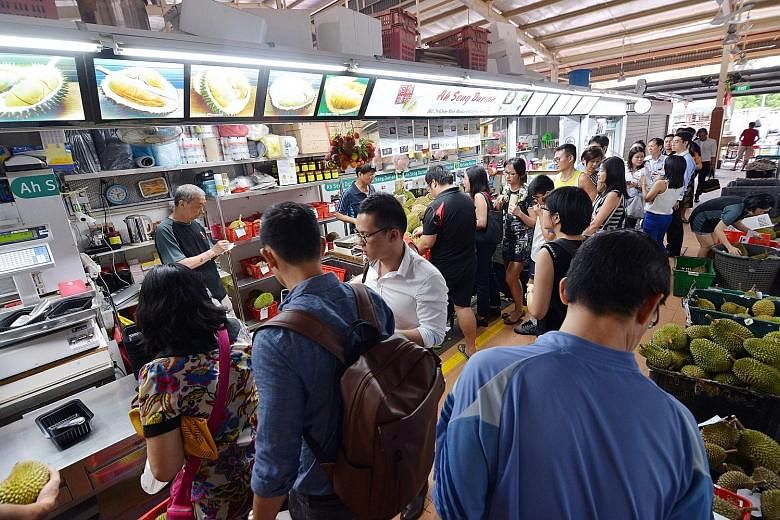 Customers waiting to buy durians at the Ah Seng Durian stall in Ghim Moh Market. Long queues have become a daily feature here, and durians are often fully reserved by the early part of the day.