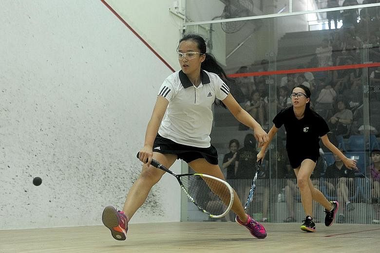 Caren Lim (left) of Singapore Chinese Girls' School hitting a forehand against Ang Hwee En of Raffles Girls School, who won their encounter 3-1 in yesterday's Schools National C Division girls' squash final.