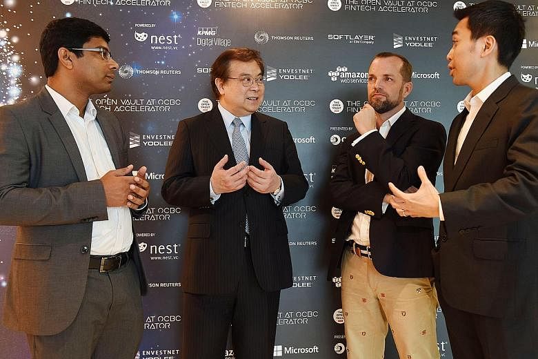 OCBC chief executive Samuel Tsien (second from left) with the founders of three collaborating fintech start-ups - (from left) Mr Rosh Cherian of CogniCor, Mr Andrew Connors of Fincast and Mr Donald Chan of BondIT. The start-ups will be conducting a t