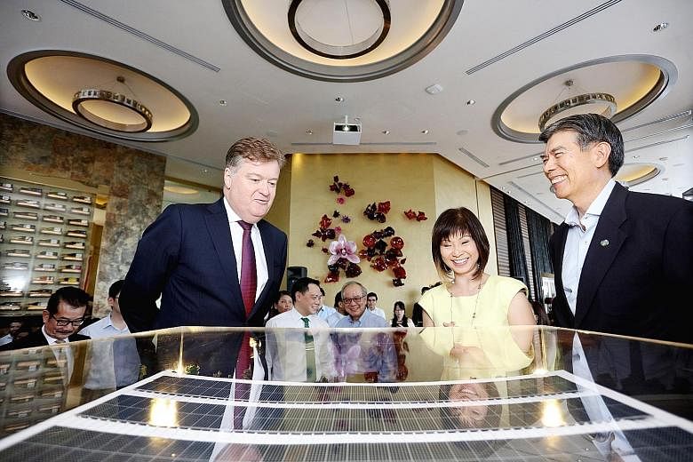 From left: CDL CEO Grant Kelley, Senior Minister of State for the Environment and Water Resources and Health Amy Khor and SEAS chairman Edwin Khew viewing a model of the Singapore Sustainability Academy. It will open in March, have 300 sq m of solar 