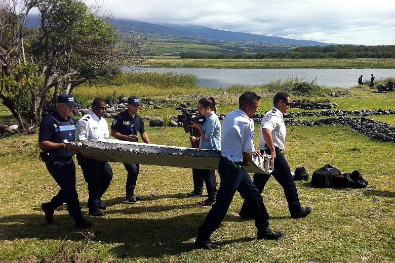 Police carrying debris recovered from Reunion Island in July last year. It was later identified as a part of the wings of the missing Malaysia Airlines plane. There have been unofficial reports that the part shows evidence of a controlled ditching.