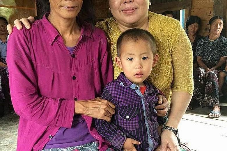 Above: Mr Pau has erected a cross in his village to remember his sister, Ms Piang, who was allegedly murdered by her employers last month. Left: Ms Piang leaves behind a young son, Mung Lam Tuang, seen here with her sister (far left) and a volunteer 