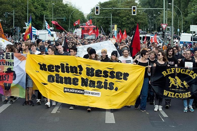Pro-refugee supporters with a banner that reads "Berlin! Better without Nazis" during a demonstration last month. Dr Merkel's open-door refugee policy has come under attack from critics.