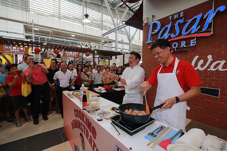 Mr Chan (in red) and chef Eric Teo at the official opening of Bukit Panjang Hawker Centre and Market. The food stalls are open at least six days a week and 12 hours a day to ensure that there are enough dining options for residents in the area.