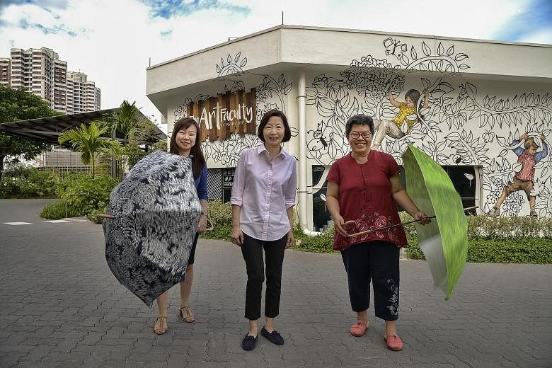 From left: Ms Jacelyn Lim, deputy executive director of Autism Resource Centre, Ms Kho and Ms Loy. The umbrellas feature floral designs by Jolie, who also did the Art Faculty's mural in the background.