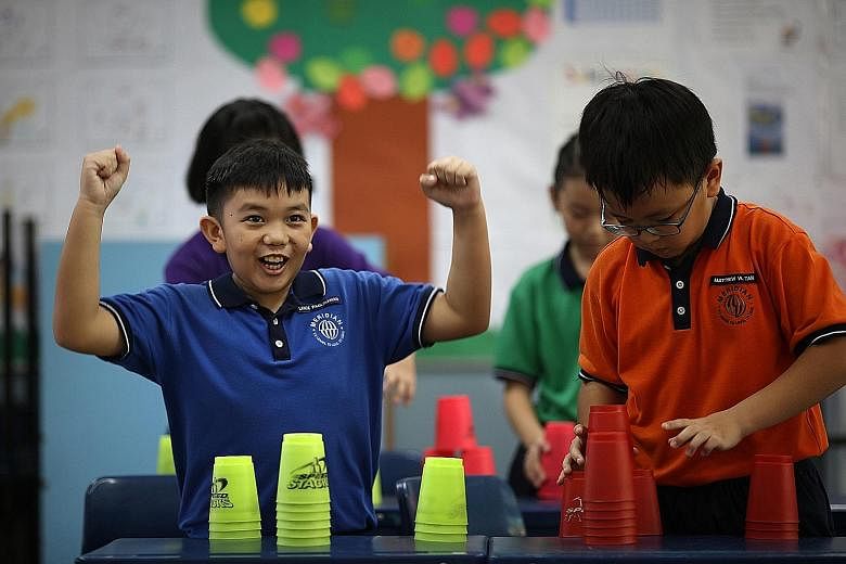 Primary 4 classmates Lance Paglinawan (left) and Matthew Tan from Meridian Primary having a go at cup stacking.