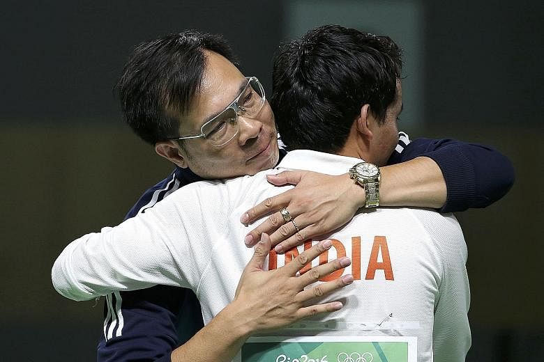 New Olympic 10m air pistol champion Hoang Xuan Vinh, who edged out Brazil's Felipe Wu, is congratulated by eighth-placed Indian Jitu Rai.