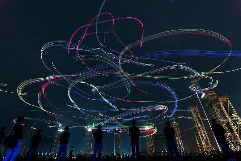 The night sky was transformed into a kaleidoscope of colours as radio-controlled illuminated kites – piloted by 42 people from toy kite maker GoFlyKite and the Army – whizzed around in the wind, captured in a long exposure shot during the 2007 NDP preview