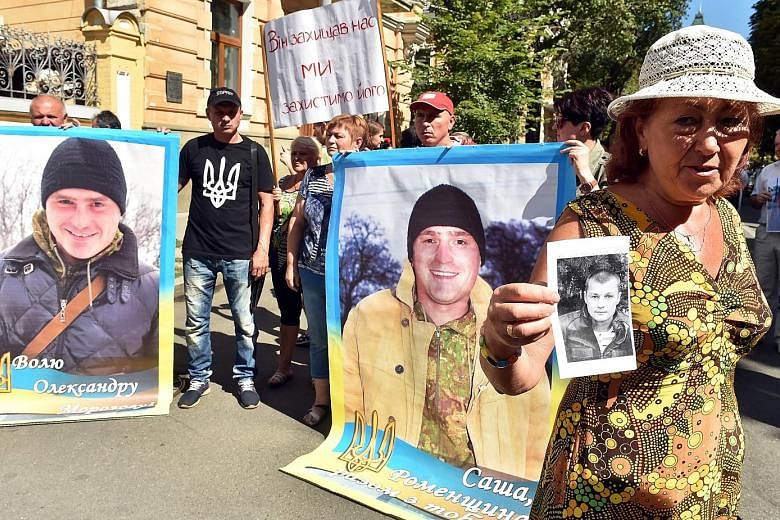 Relatives holding placards with pictures of Ukrainian servicemen captured by pro-Russian separatists in the uncontrolled territories of Ukrainian Donbass at a rally yesterday outside the office of President Petro Poroshenko in Kiev. Ukrainian pilot N