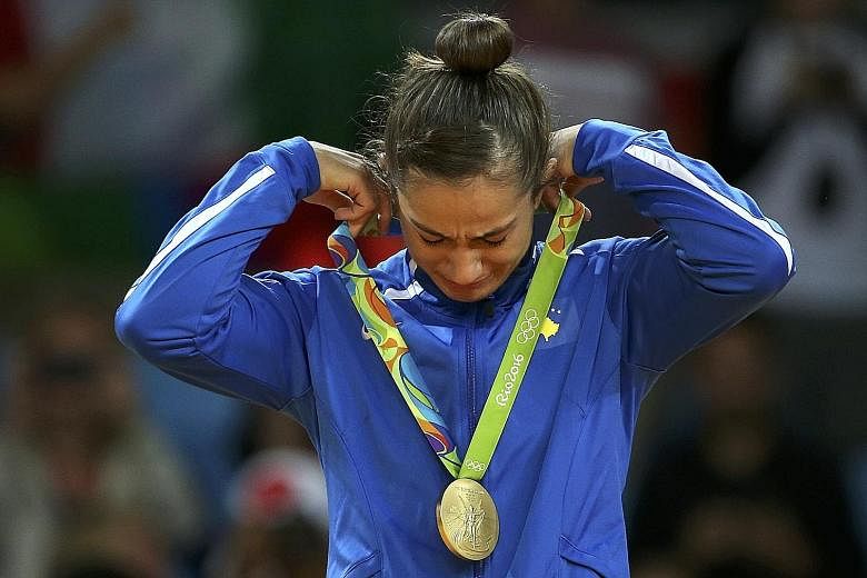 Judoka Majlinda Kelmendi is overcome by emotion after winning gold in the women's 52kg category. Hers is the first medal won at an Olympic Games by Kosovo, which has a population of only 1.8 million.