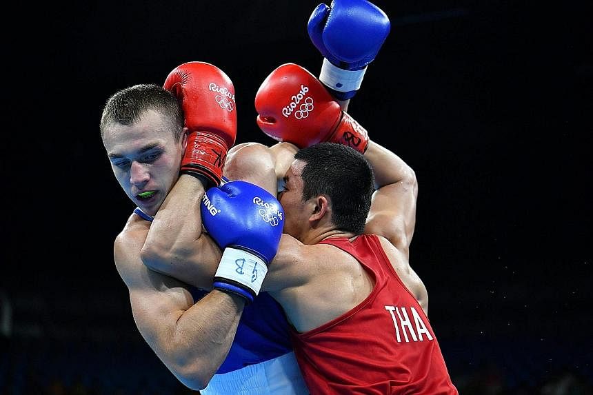 Thailand's Saylom Ardee (right) appears to use every part of his arms to fight Belarus' Pavel Kastramin during the men's welterweight round-of-32 match on Sunday. The Thai proved successful as he advanced on a split decision to the next stage.