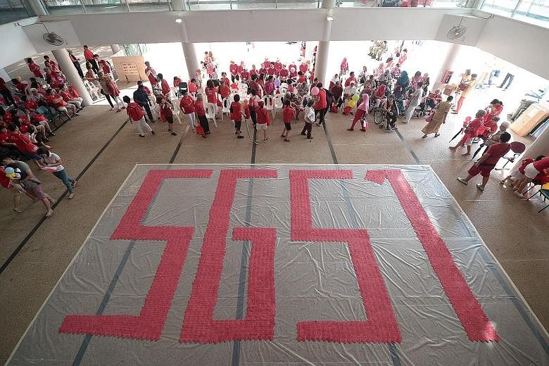 Members of the public and the Hua Yuan association take part in a mass community walk as part of National Day celebrations yesterday. This SG51 symbol won Kampong Kembangan Community Club a place in the Singapore Book of Records for the largest forma