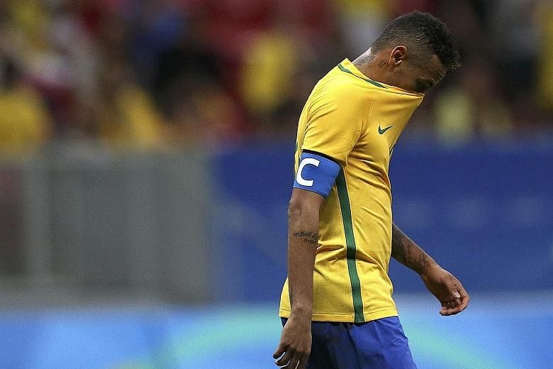 Left: Neymar walking off the pitch after Brazil's 0-0 draw with Iraq, leaving the hosts needing victory in their final group game against Denmark today. The Selecao had already suffered one disappointment this year with their early Copa America exit 
