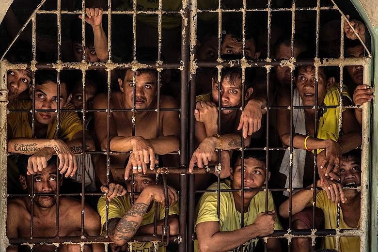 Inmates look out from their cell in Quezon City Jail. Originally built for 800 inmates, the prison now houses almost 4,000. The overcrowded conditions at the prison have prompted the government to build new facilities.