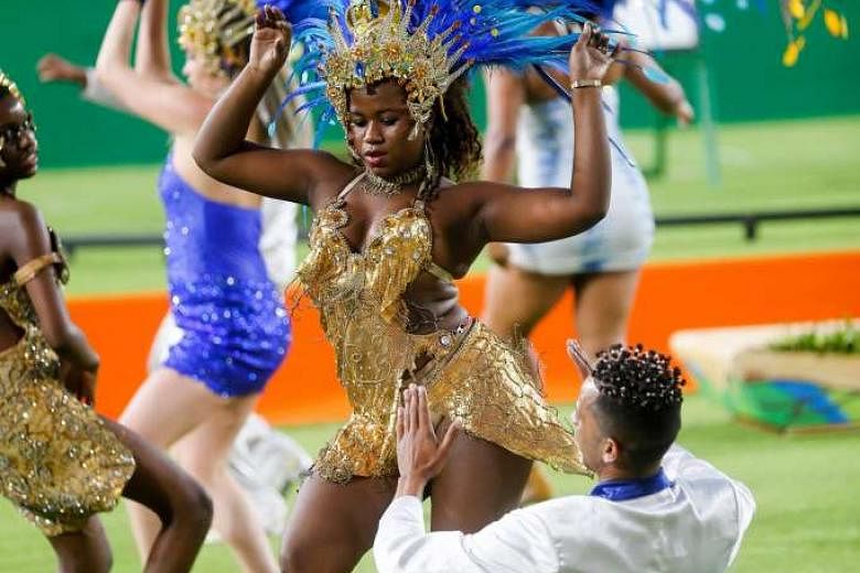 Samba dancers perform before the medal ceremony of the Rio 2016 Olympic Games Archery events in Rio de Janeiro. Brazil's population seems to be warming to the Olympics, despite dour pre-games polls. There are still dirty and dangerous conditions outside t