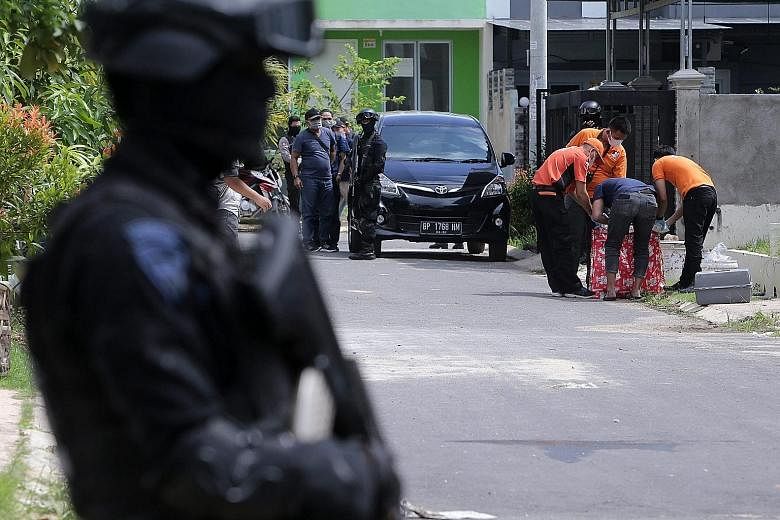 Indonesian anti-terror police searching for evidence during a raid at a residential area in Batam last Friday. Six people were arrested on the island last week. The cell leader had planned to fire a rocket at Singapore's Marina Bay.