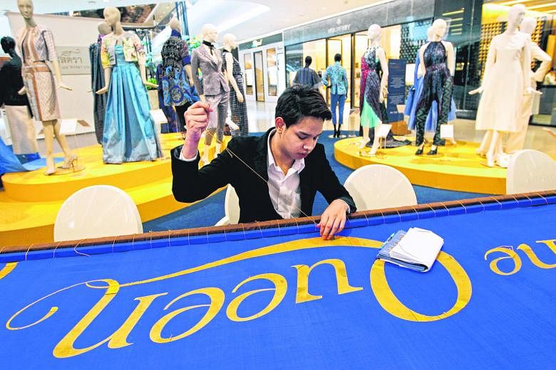 A Thai well-wisher using golden thread to embroider "Long Live the Queen" on a 7m-long silk banner, ahead of Queen Sirikit's birthday preparations yesterday in Bangkok. Thailand's popular Queen Sirikit will turn 84 tomorrow.