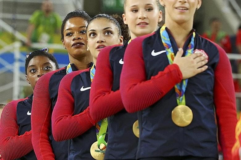 While Simone Biles wobbles slightly on the beam (top), she still nailed a team-high 15.300, and her brilliant performances gave the United States team - (above from right) Aly Raisman, Madison Kocian, Laurie Hernandez, Gabby Douglas and Biles - a com
