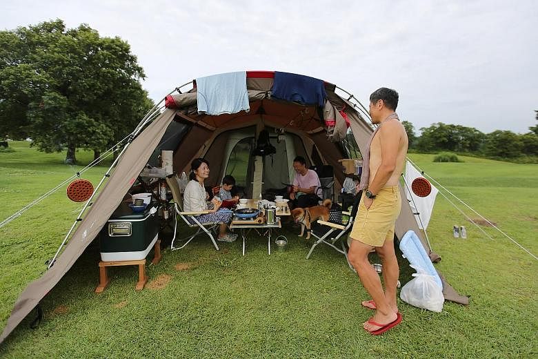 Campers having a good time in a field in Sanjo, Niigata Prefecture. With Mountain Day, Japan now has 16 public holidays a year.